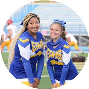 Two cheerleaders pose and smiling