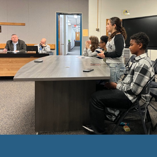  Student stands to present at school board meeting