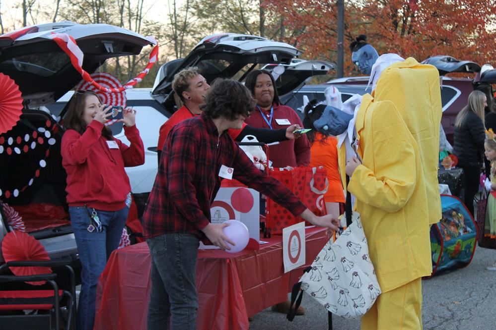  Characters from Beetlejuice take candy from a table at the Logan Trunk-N-Treat event.