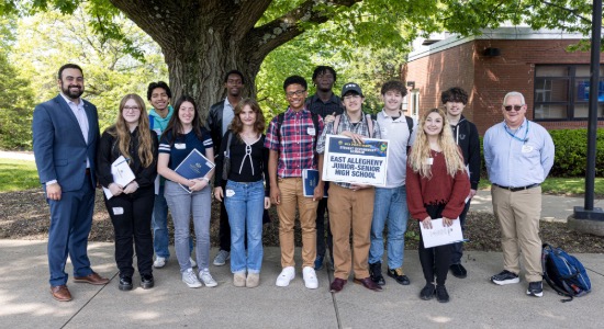  Group of students pose with senator and their teacher in front of a large tree