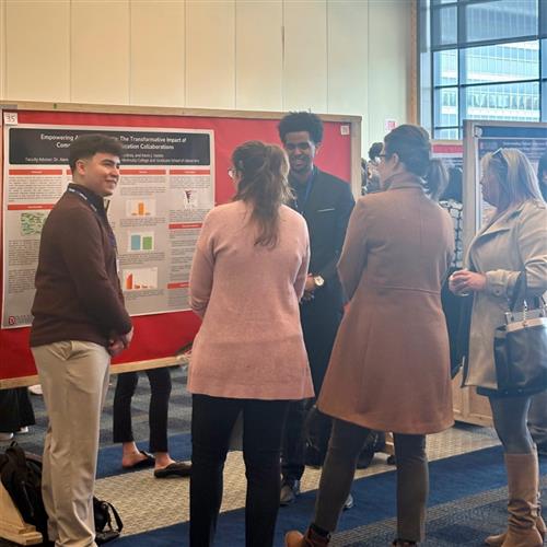 Group of people at a poster session discussing research